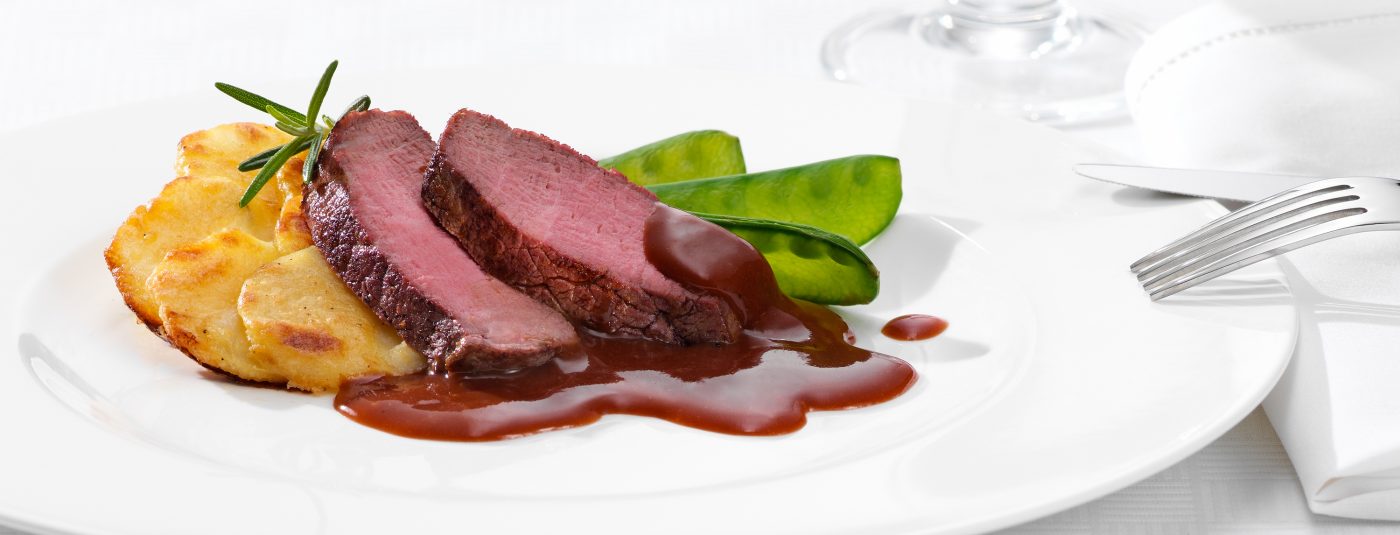 Foodverpackungen rosa rindfleisch mit rotweinsauce auf weissem teller und zuckerschoten lecker