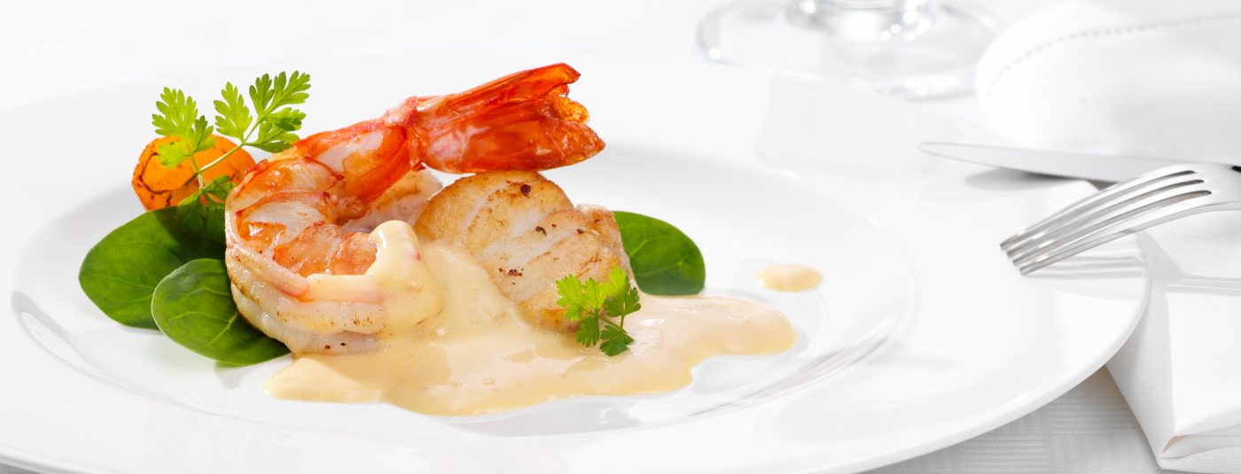 Foodverpackungen vor hellem Hintergrund Scampi mit Sauce auf weissem Teller