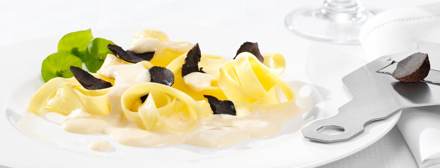 Foodverpackungen nudeln mit trüffeln und trüffelsauce auf weissem teller foodshots
