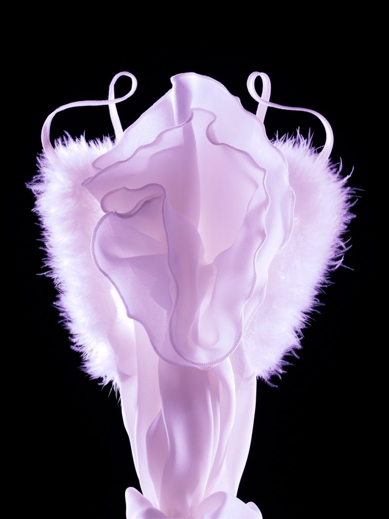 Legeware Blume rosa Lilie ist aus Frauenkleid gelegt worden vor schwarzem Hintergrund