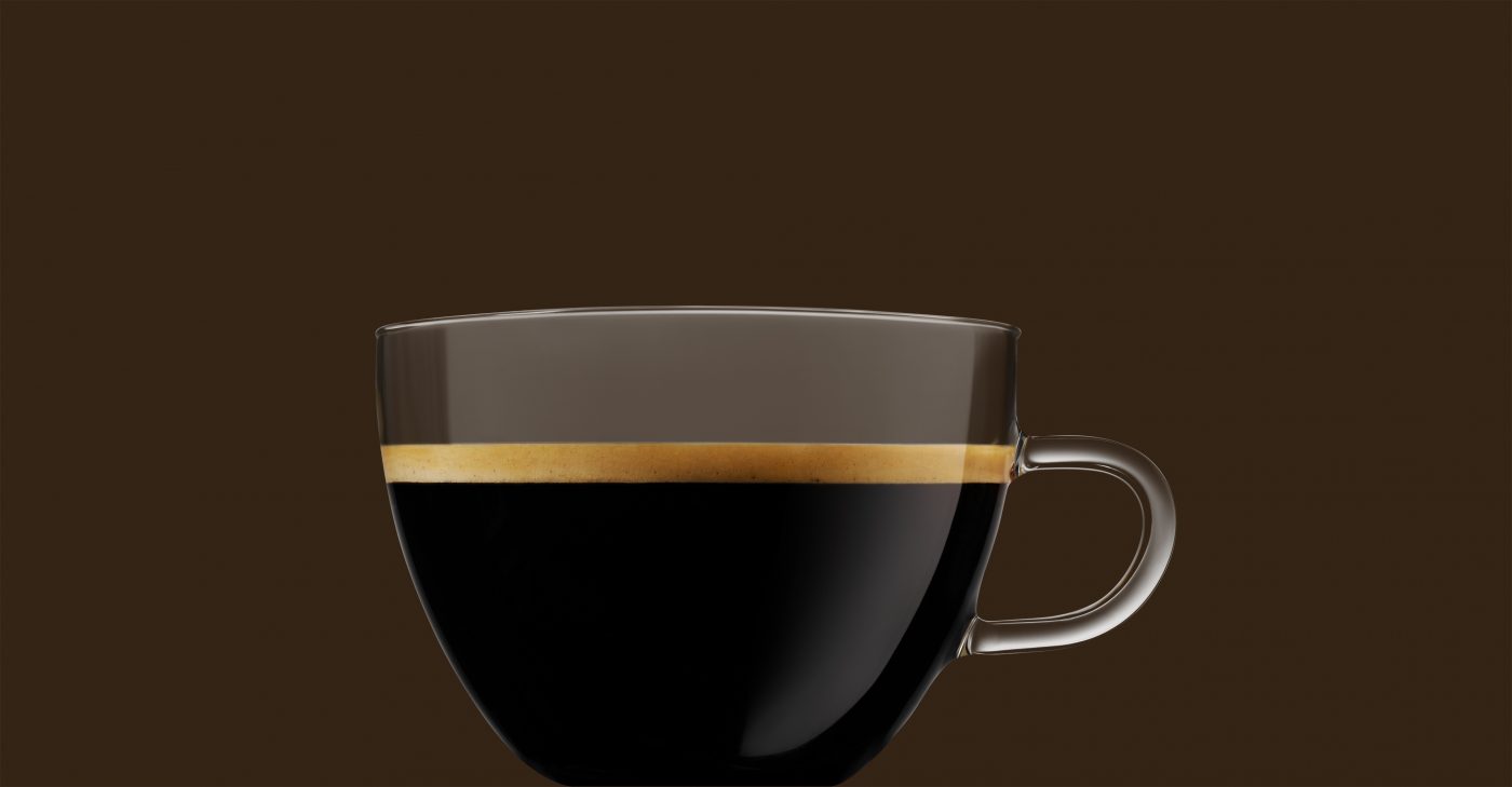 Kaffeetasse aus Glas gefüllt mit schwarzem Kaffee mit Crema vor braunem Hintergrund