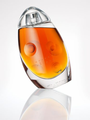 cognac Bottles with golden liquid reflections in the glas still life photography