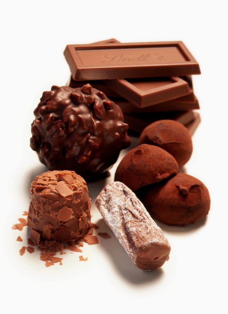 group of chocolates on white underground cocoa powder