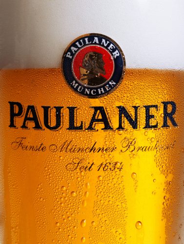 kaltes Bier im Glas von Paulaner goldgelbe Farbe viele Tautropfen kondensiert