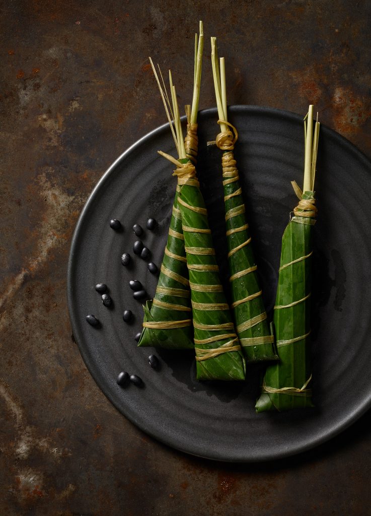 Japanisches Foodstyling chimakis liegen auf handgetöpfertem Teller rostiger Metaluntergrund dark food photography