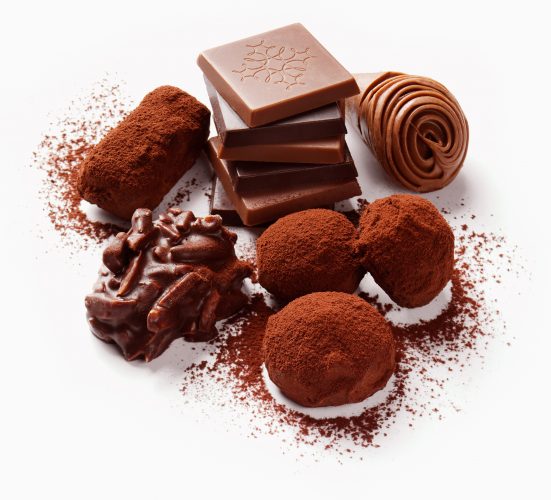 Pralinen Gruppe mit verschiedenen Schokoladen überstreut mit Kakao auf weissem Hintergrund