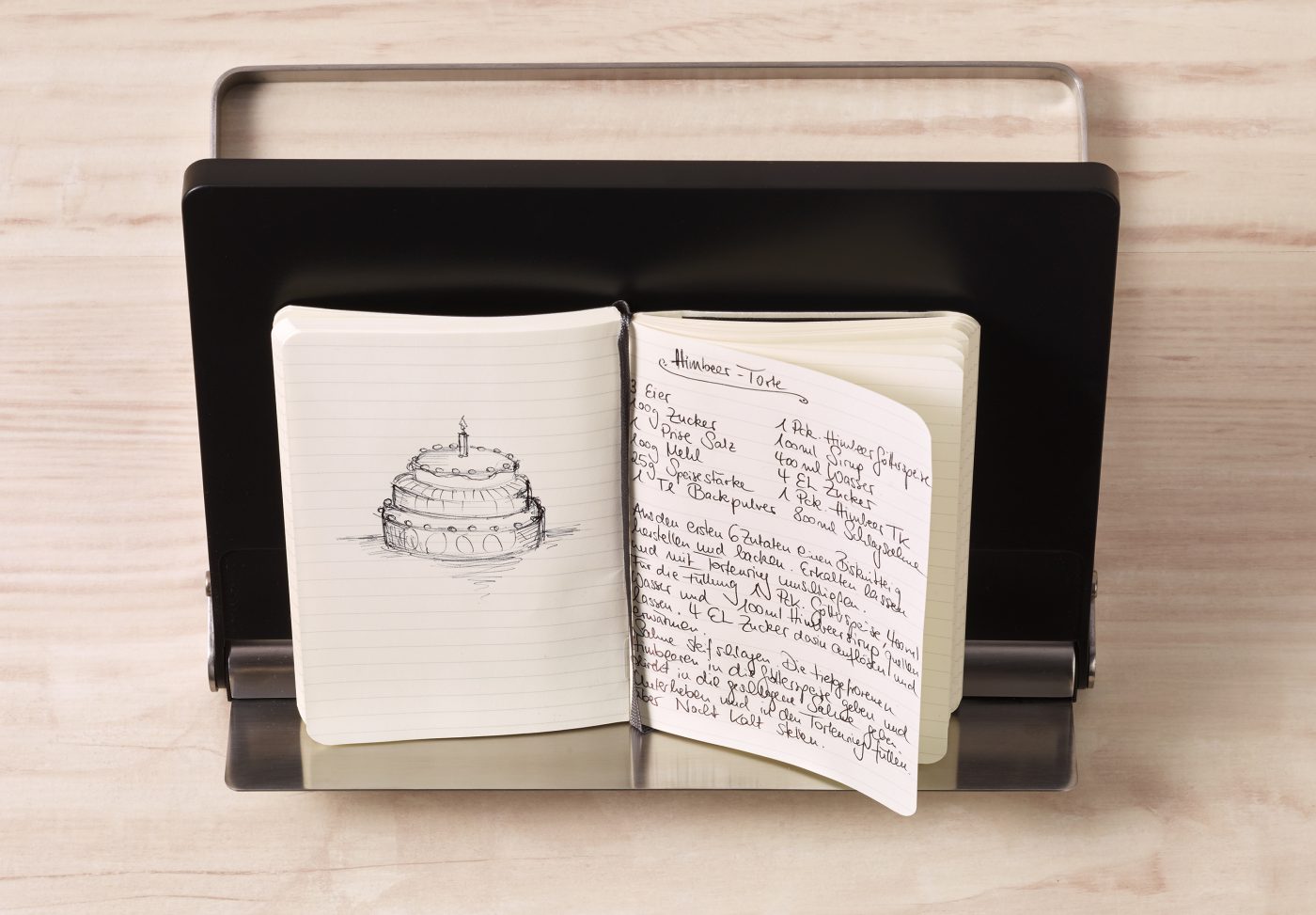 ein handgeschriebenes patieniertes Kochbuch liegt auf einem Kochbuchständer. Foto für die Food-Verpackungen