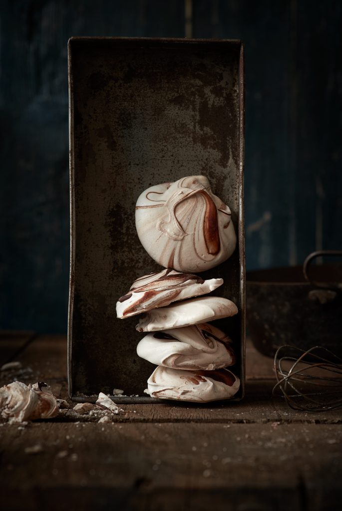 mehrere schokoladen merengue sind in einer alten Blechdose gestappelt