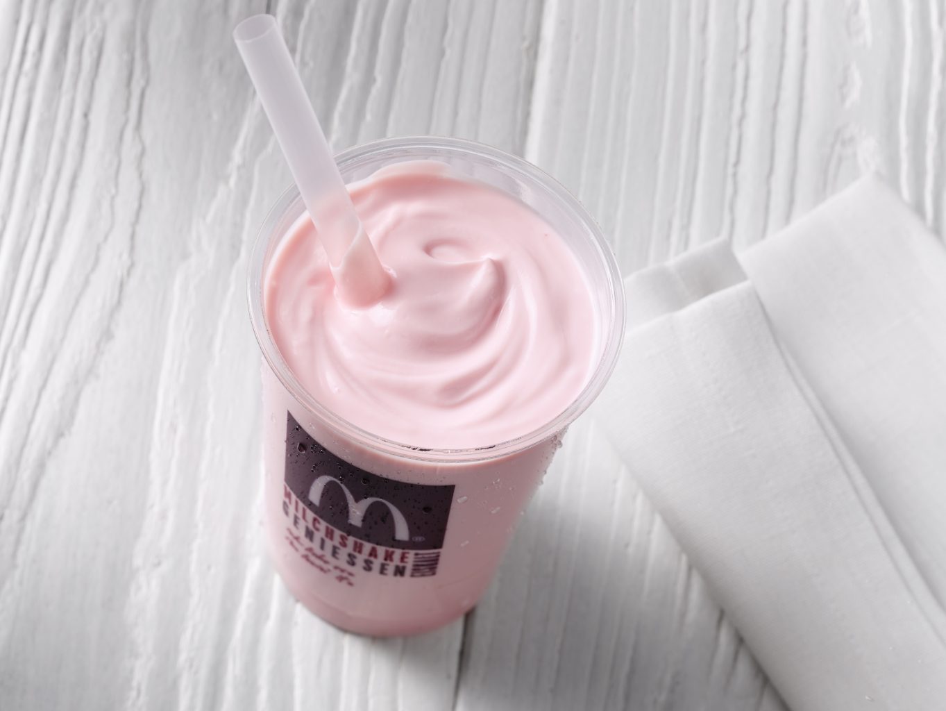 Local Store Marketing of two McSundae Icecream with Caramel and Chocolate Sauce drops of Sauce on the Unterground Caramel Chunk white wooden Unterground