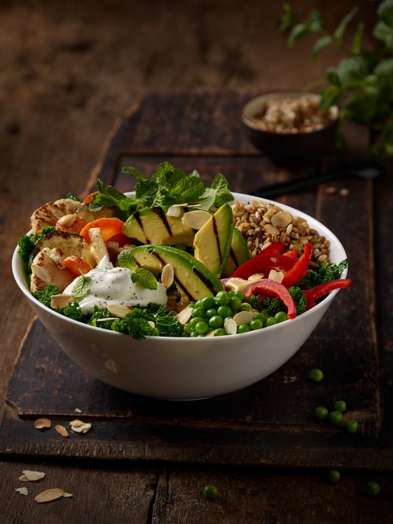 freshly prepared Grilled Avocado Curry Bowl in wooden seting